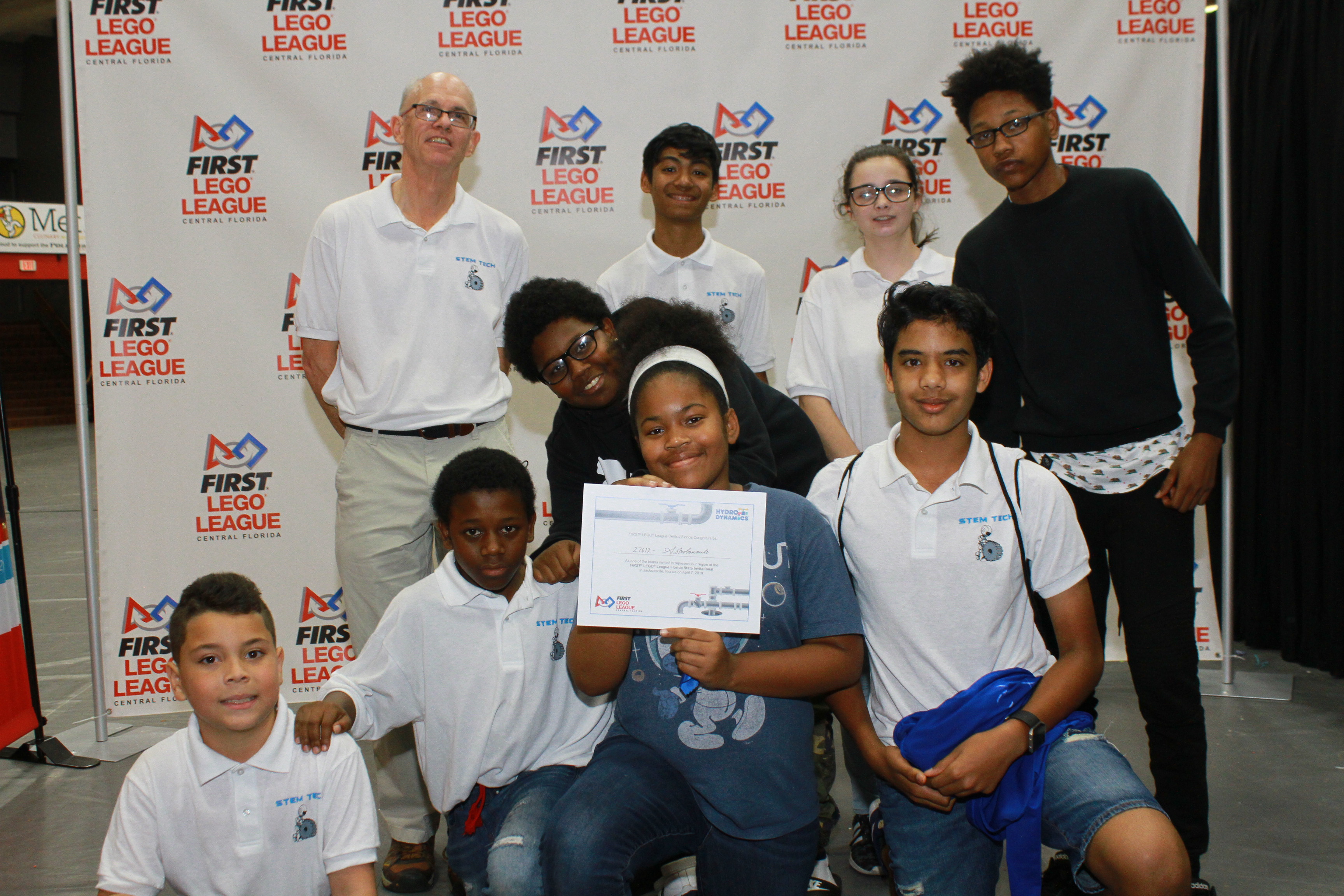 A class poses for a photo with their certificate