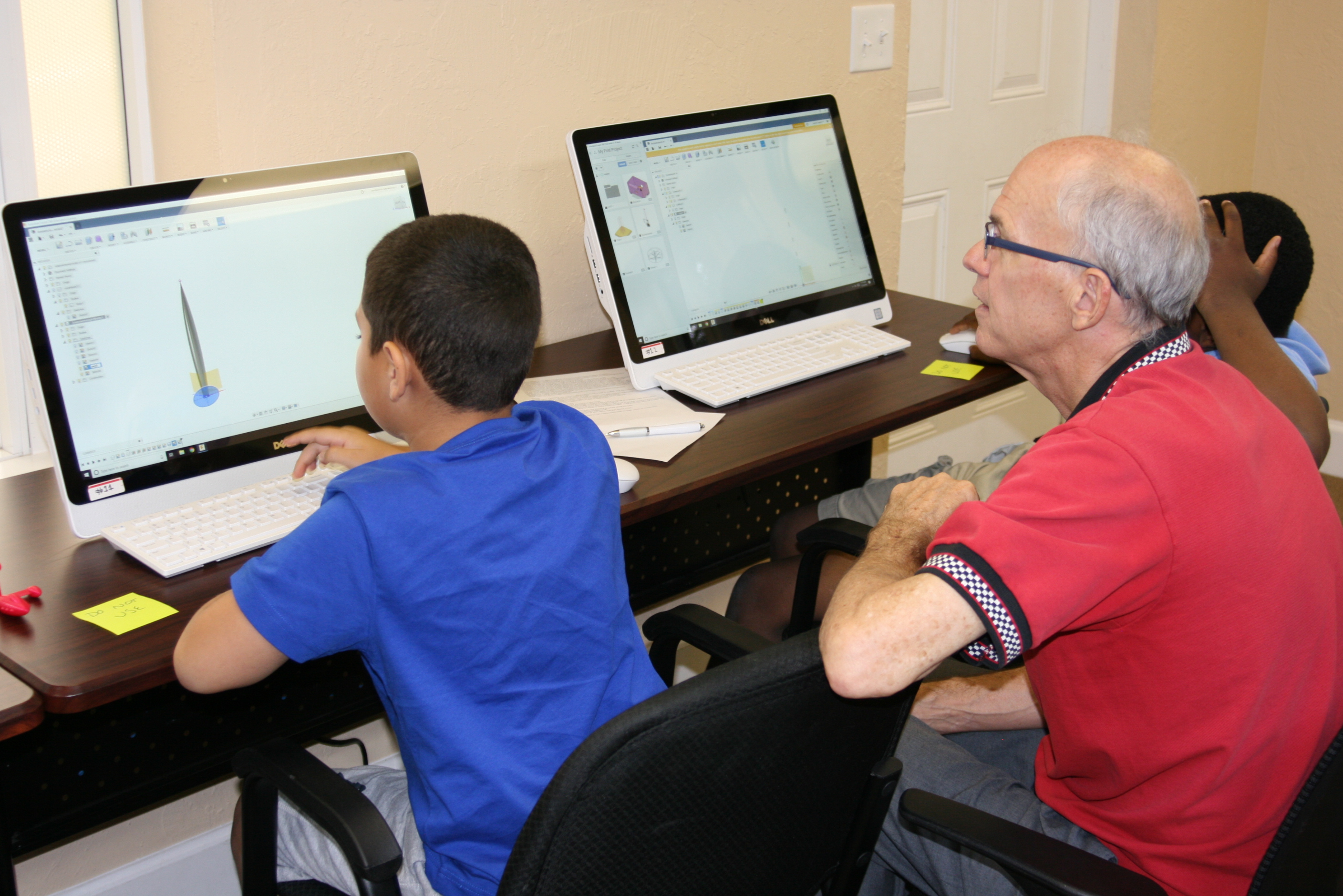 Students and instructor looking at and working on a computer