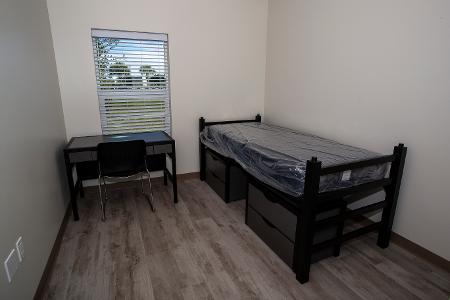 View of an empty student room with base furniture  
