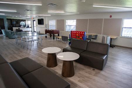 An empty common area with chairs and games 