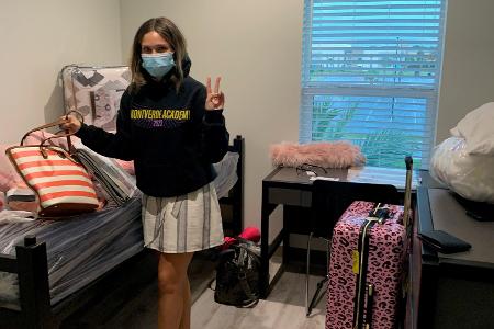 A students moving into their dorm, posing for a photo 