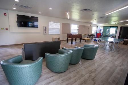 An empty common area with chair and games 