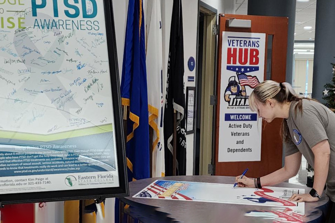 Student signing a pledge to raise PTSD awareness in front of the service center on the Cocoa Campus.