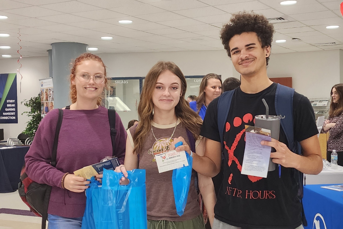 A cheerful group of students at an on-campus event, proudly posing with their EFSC swag bags.