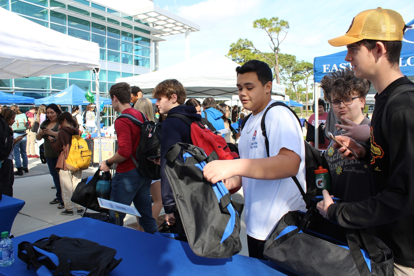 An image of a community-building welcome event: students waiting in line to receive free campus goodies and EFSC themed items at an event check-in table
