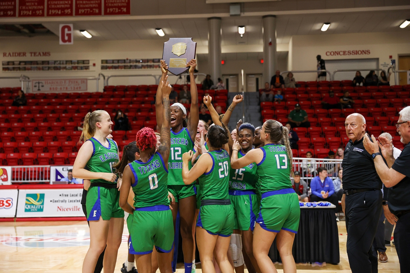 A vibrant photo capturing the celebration of EFSC's Women's Basketball team after they won the State Championship while holding the trophy.