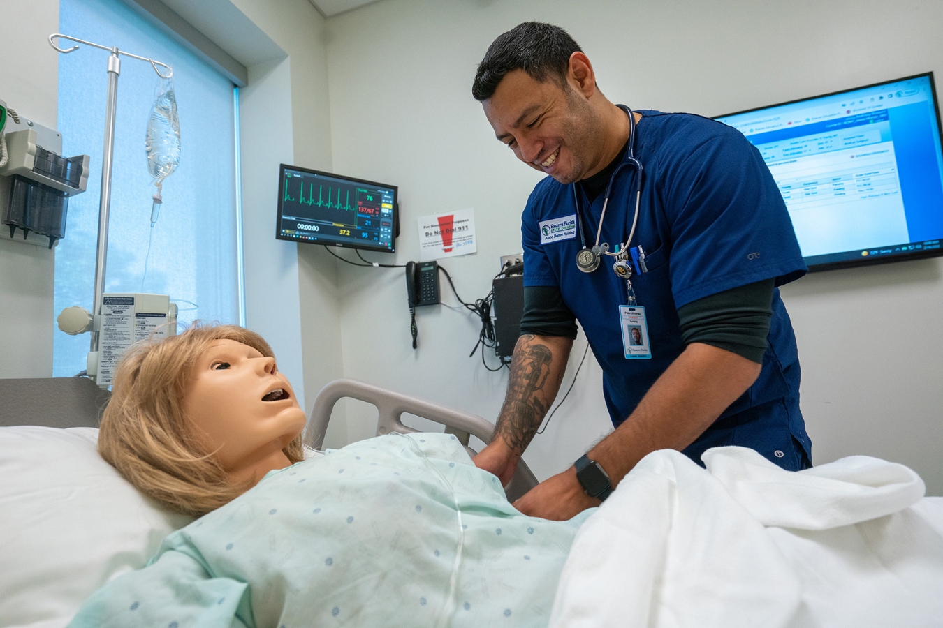 A male nursing student engaged in hands-on training with a healthcare dummy in an advanced nursing classroom at EFSC's Health Sciences Institute