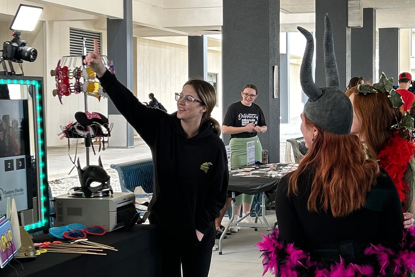 Lively student interaction at an Office of Student Life event: Costumed students embrace the selfie machine for a memorable photo.