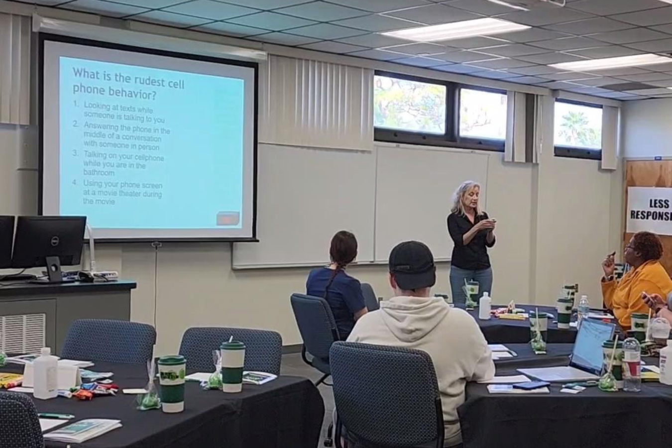 Dr. Barbara Kennedy presenting the introduction slide of a PowerPoint at a Green Dot Bystander Training session on the Melbourne Campus as students attentively listen