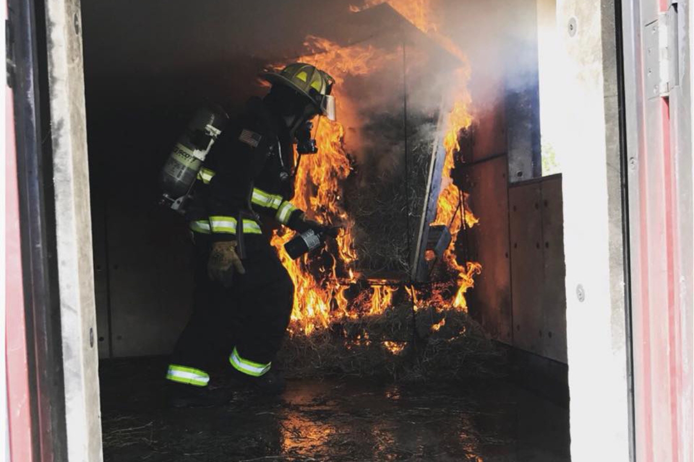 firefighter student participates in a training activity that involves navigating a burning building