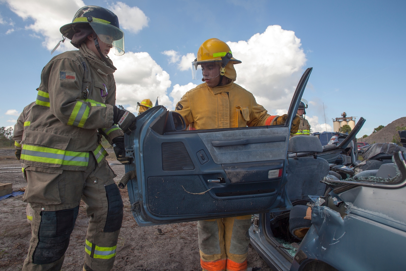 fire science students taking apart a car as part of an exercise to become familiar with the tools of the trade and working together as a team