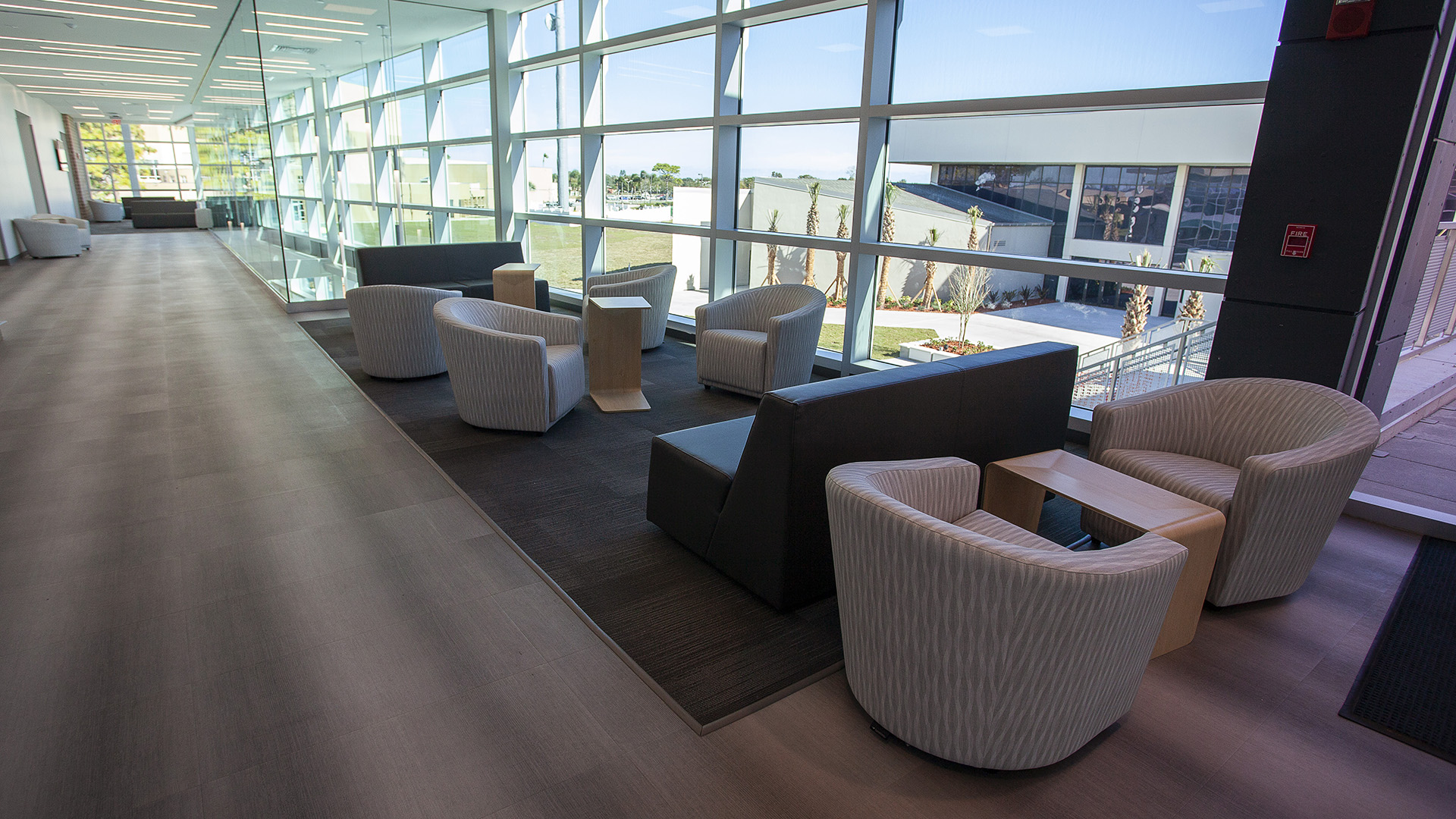 A wide shot photo of the upstairs area with lounge chairs and tables in the student union