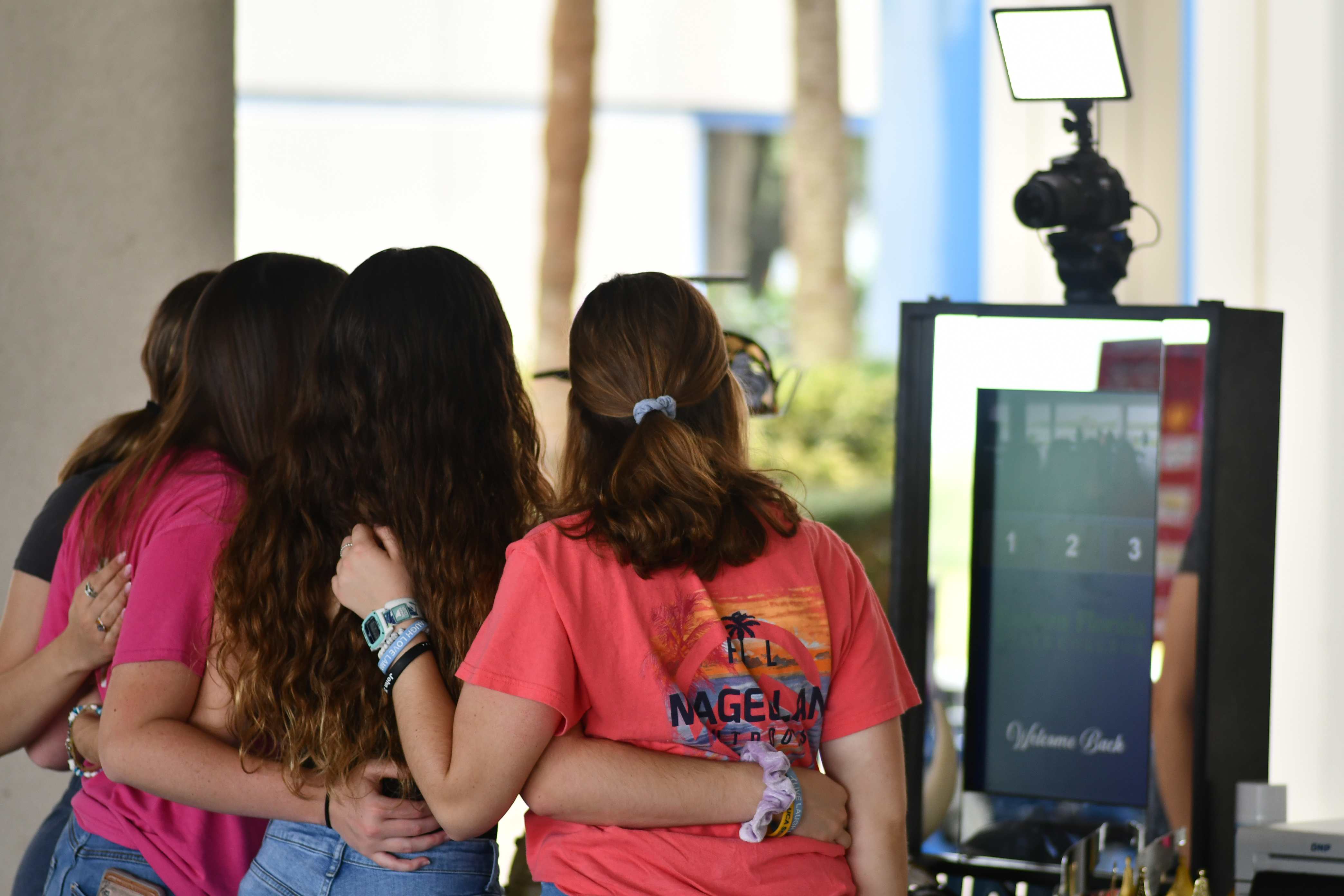 A group of students pose together in front of a selfie machine on the Palm Bay Campus during an event