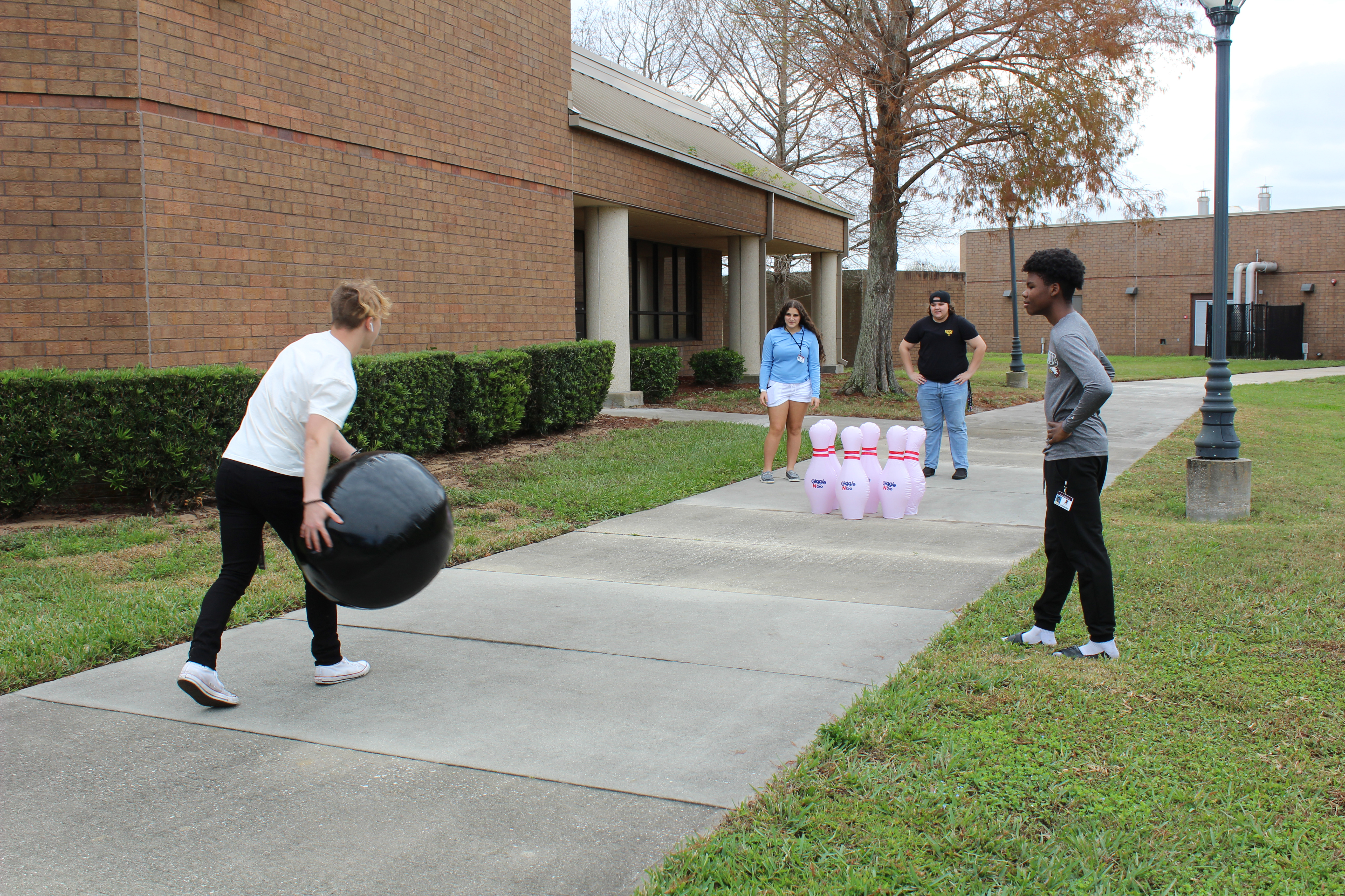 Diverse group of students playing a giant bowling game outdoors on the Titusville Campus during a student event