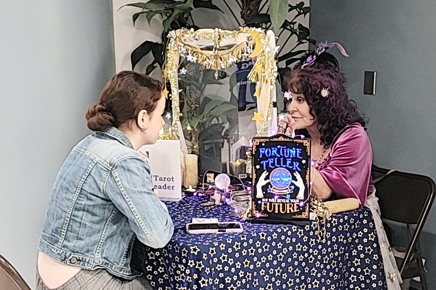 A female student getting her fortune read at a Cocoa Campus student event.