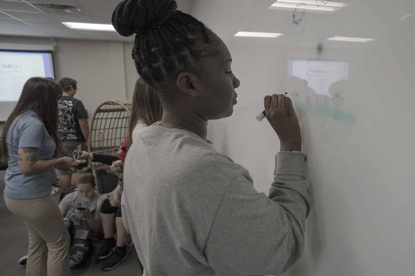 A woman writing on a white board.