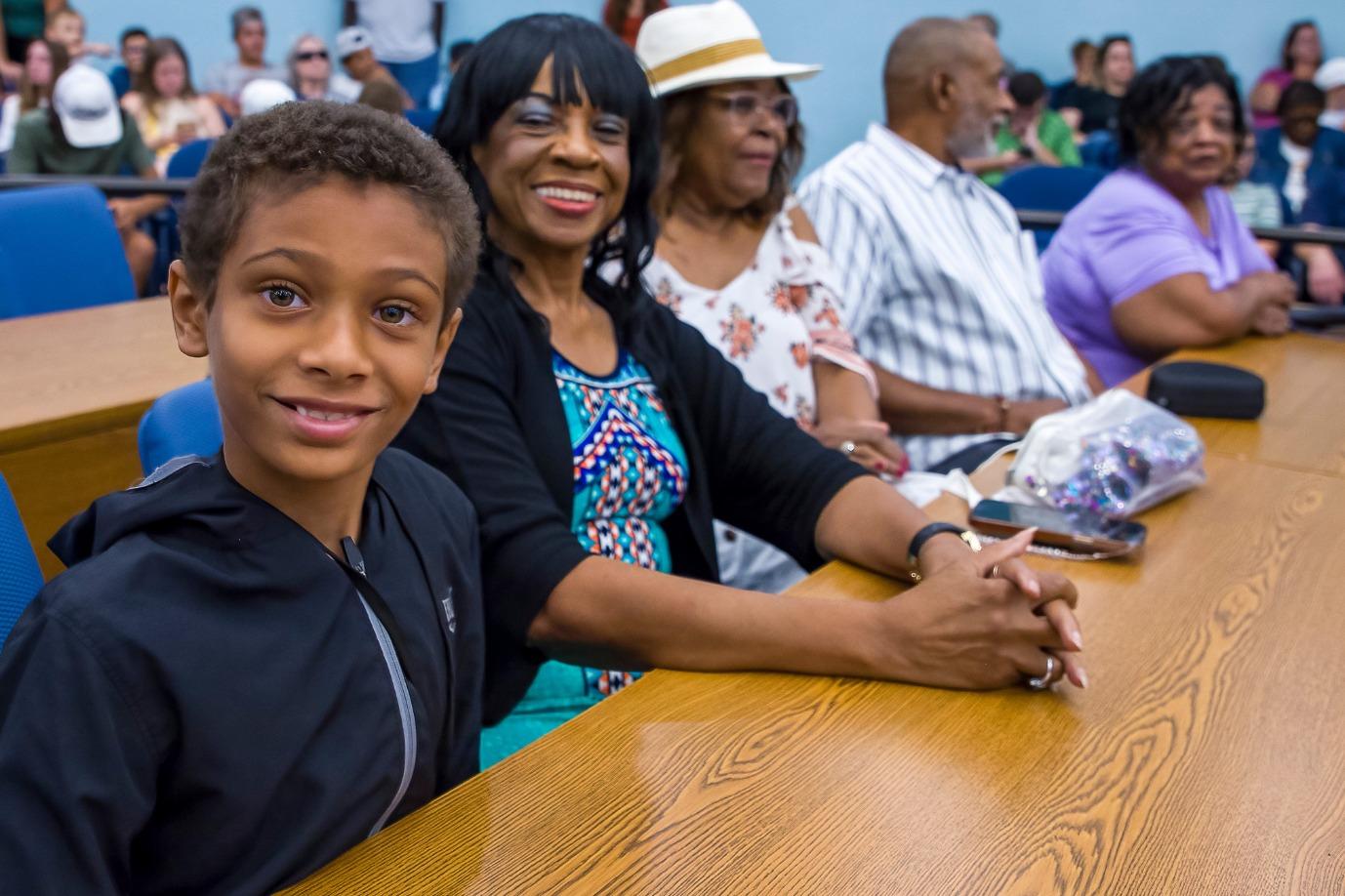 A family is smiling and posing for a photo at a table during the golf camp's celebration event