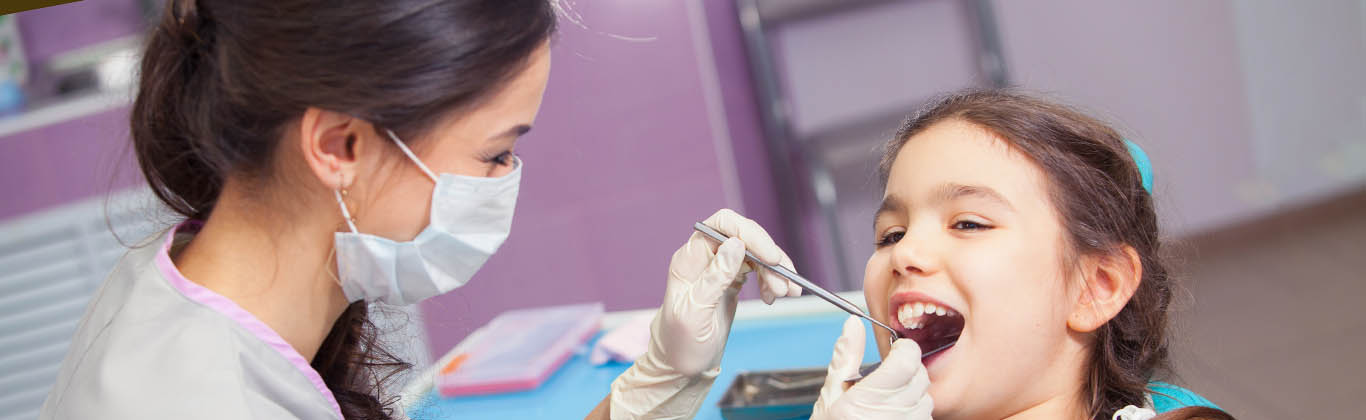 Dental hygienist working with child patient