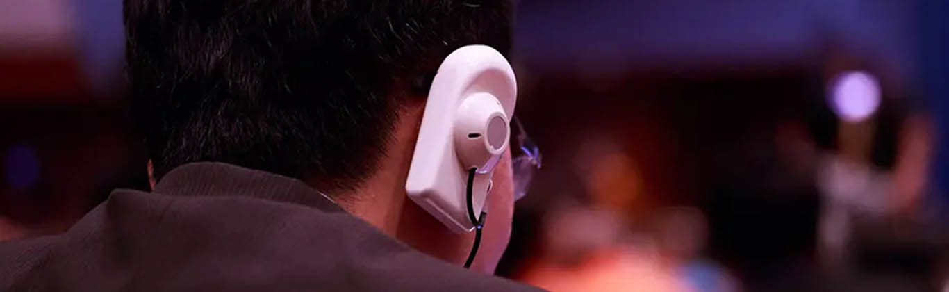 An interpreter listening to speech through an earpiece.