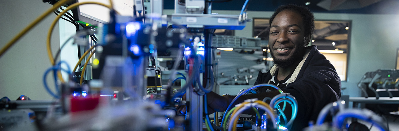 Male robotics student looking at computer components.