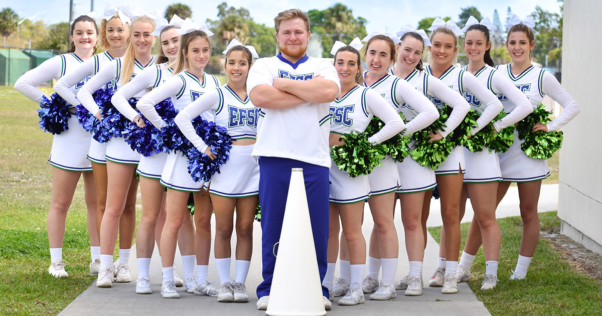 Group of women and one man in EFSC cheerleading uniforms with pom poms and cheer megaphone