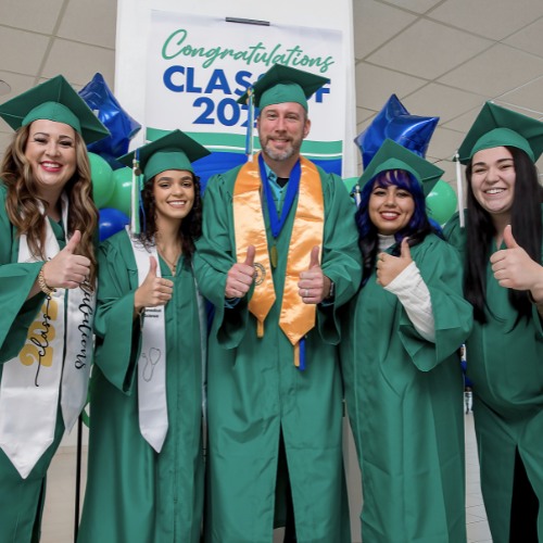 five graduates in caps and gowns