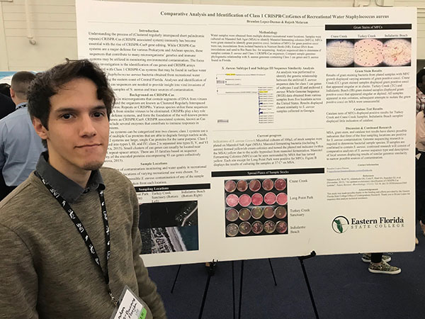 Male student Brandon Lopez-Duenas with research poster