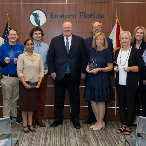 An image of twelve EFSC employees standing with President Jim Richey, holding their STARS awards.