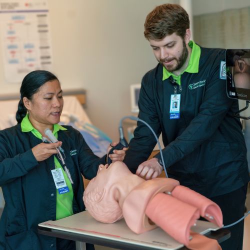 Two respiratory students intubating a dummy